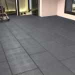 Dark-gray-interlocking-rubber-flooring-tiles-installed-in-a-gym-area-adjacent-to-a-pool-deck