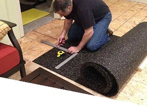 man-measuring-and-cutting-rolled-rubber-gym-flooring-with-straight-edge